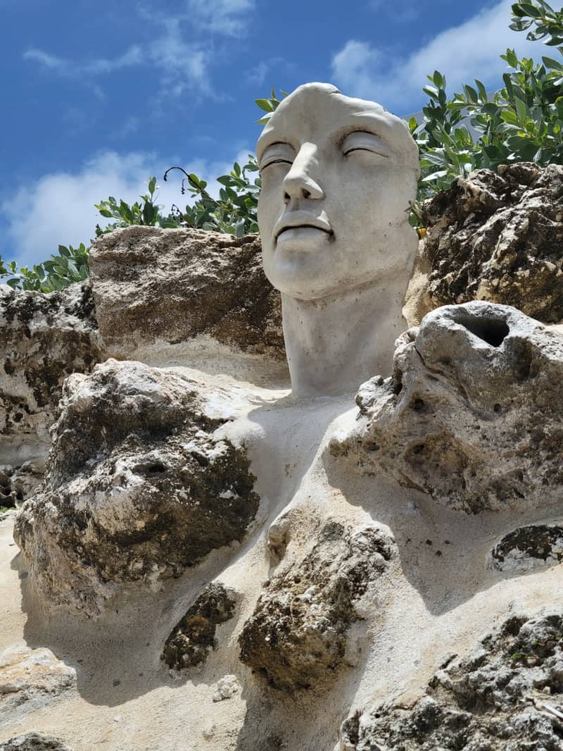 Carved stone face set into coral rock